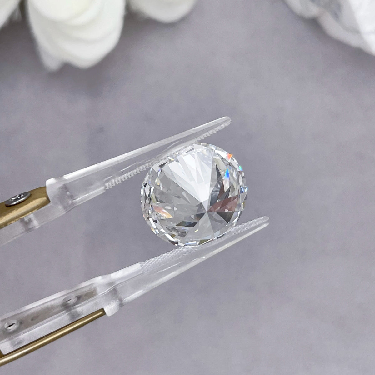 Lab Grown Diamant 3ct Round Brilliant Cut in Pinzette, seitliche Nahaufnahme des Lichtspiels