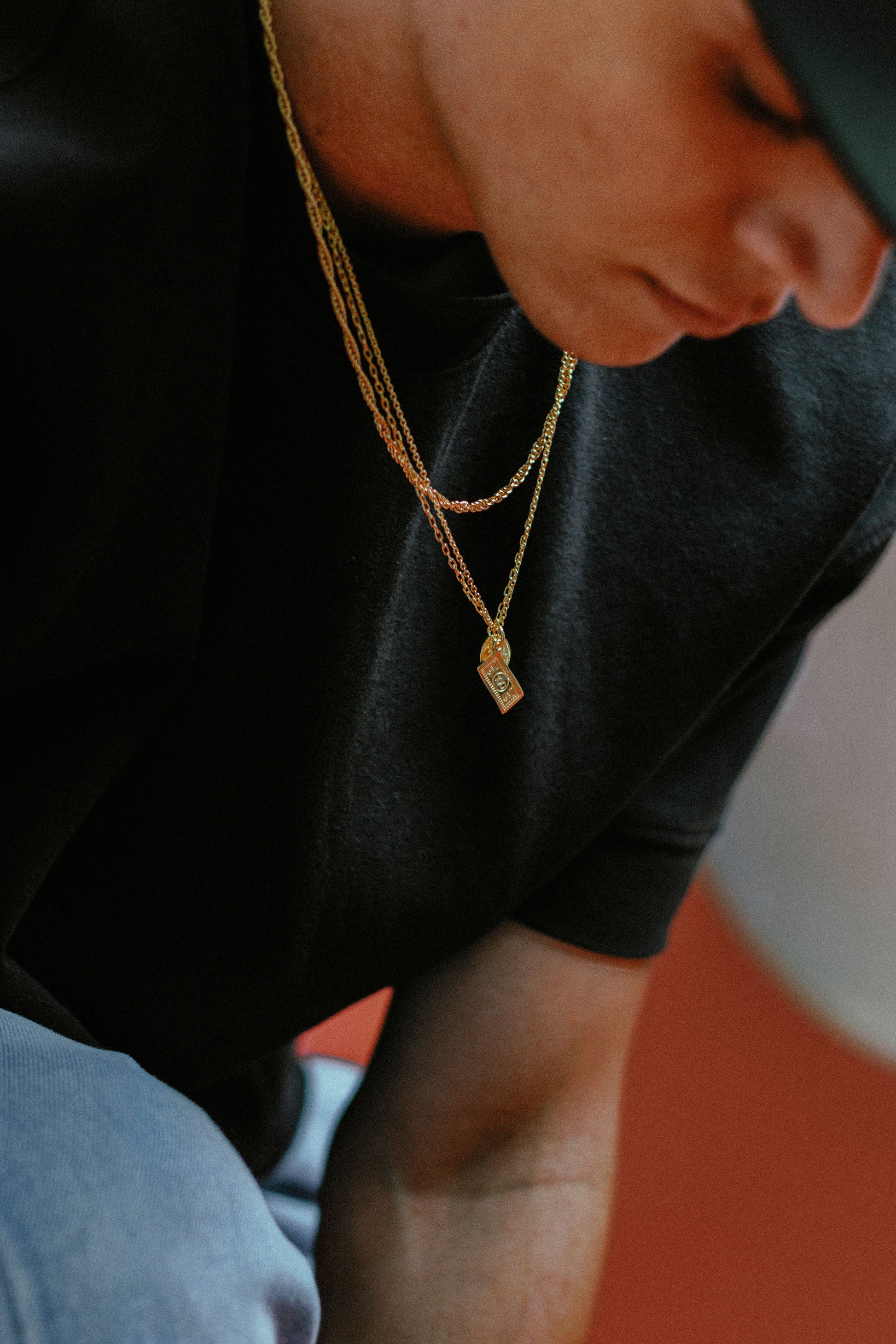 Mann trägt goldene Anhänger und Ketten – Herrenschmuck von Z Juwelier
